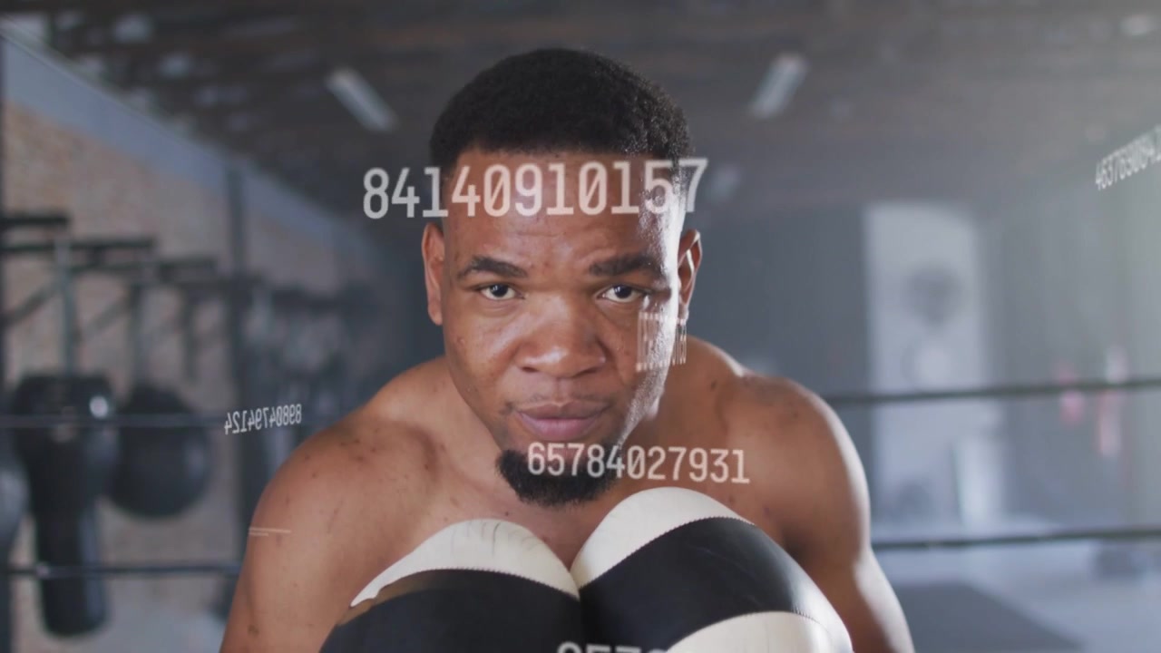 Male boxer throwing straight punch to camera, training with floating numeric graphics over gloves