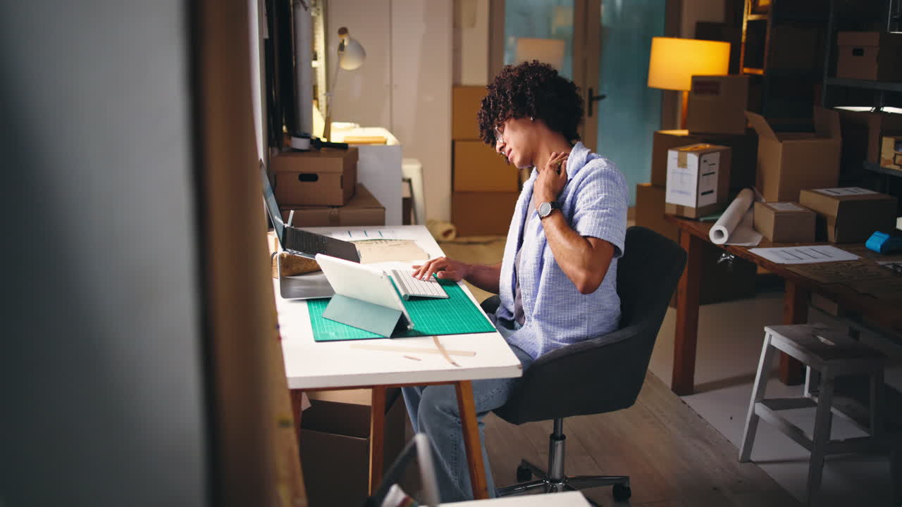 Young Man Working on Laptop Experiences Neck Pain in Office