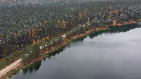 Winter-and-Fall-Fusion:-A-Scenic-Drive-Alongside-a-Snowy-Lake-and-Colorful-Forest,-Evoking-Moody-Atmosphere