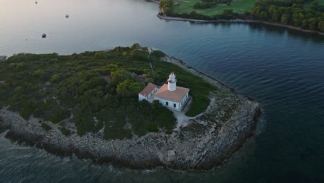 Drone-bird's-eye-view-orbit-around-Alcanada-lighthouse-Mallorca-Spain