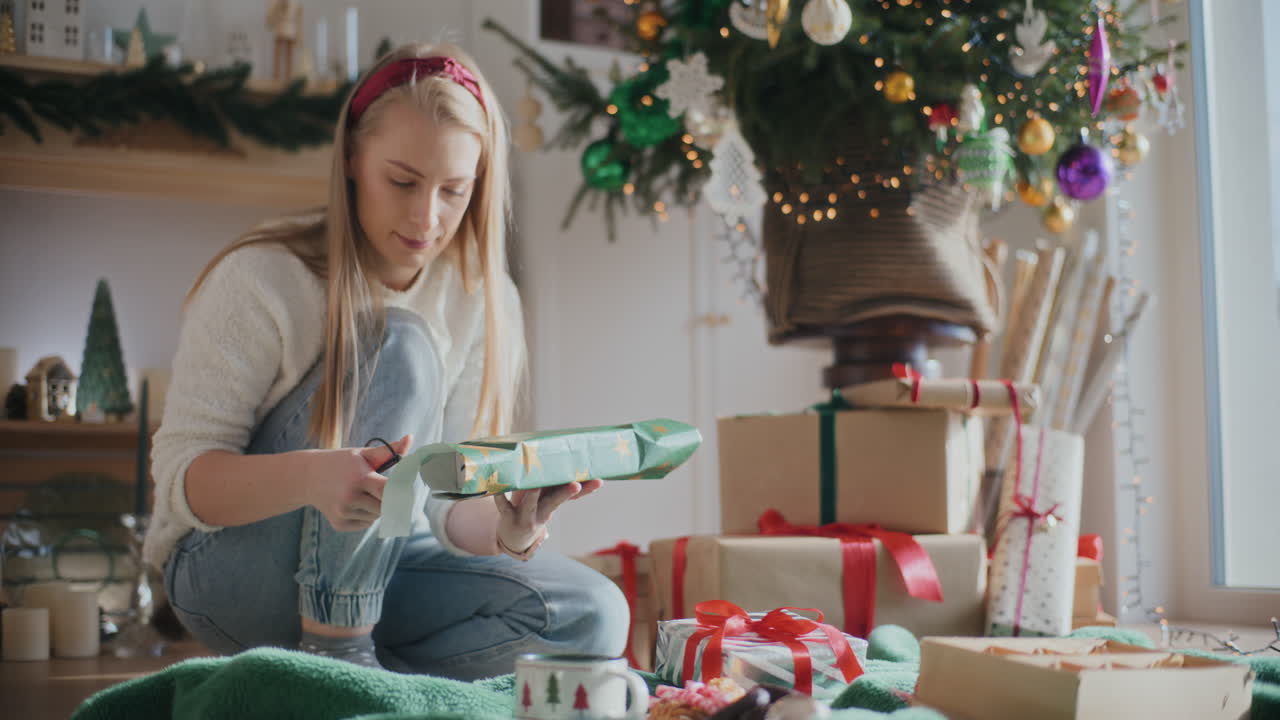 una mujer hermosa envolviendo un regalo de navidad en casa.