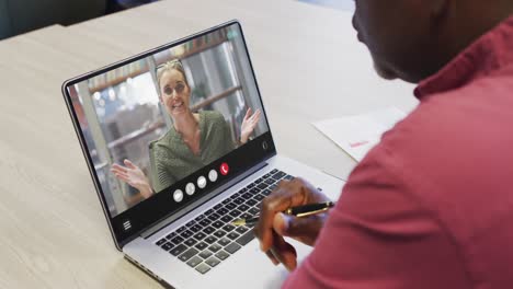 African-american-man-using-laptop-for-video-call,-with-business-colleague-on-screen