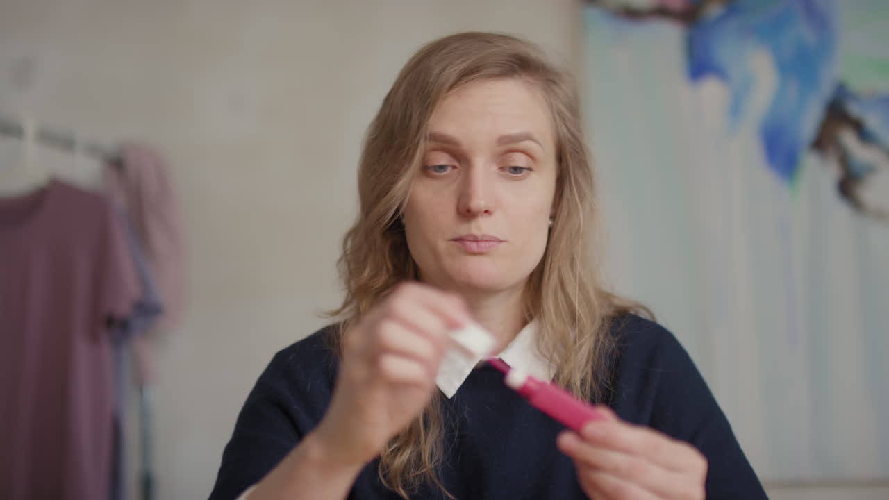 Donna che dimostra l'applicazione del rossetto