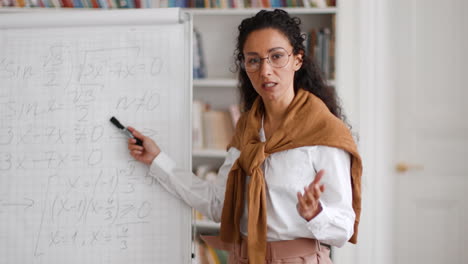 female math teacher explaining on whiteboard