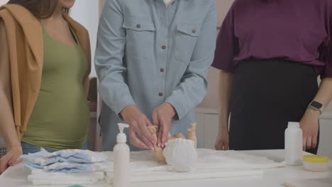 teacher in class with two pregnant woman and toy baby