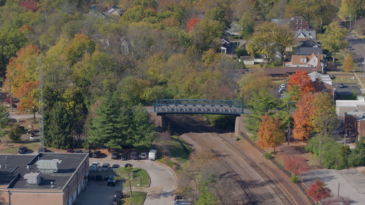 vista aérea del puente sobre las vías del tren en la pequeña ciudad de estados unidos en otoño con descenso