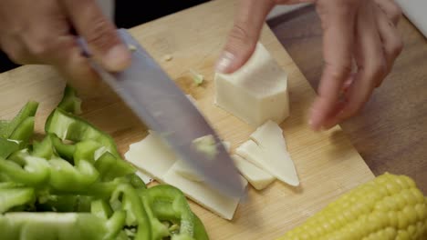 mujer cortando queso en la tabla de cortar