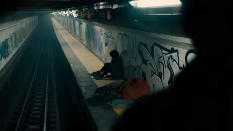 homeless person sitting in a subway station