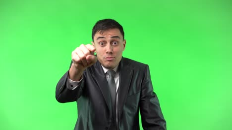 man in a suit pointing and expressing disapproval on green screen