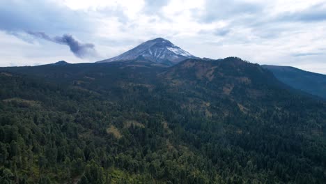 descending drone shot of volcanic fumarole at popocatepetl in mexico and surrounding forest