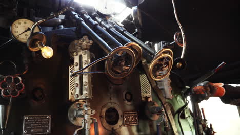 close shot inside steam train locomotive, train driver control gears