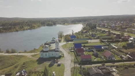 aerial view of a russian village by a lake with a church