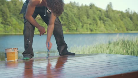 joven pintó el techo de la cabina del barco de madera con pintura protectora exterior bondex