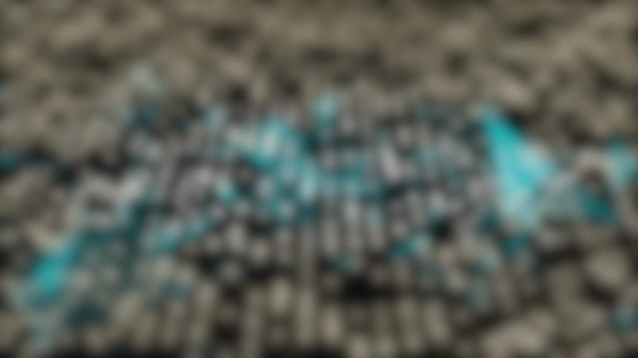 Blurred bokeh lights dotted background with blue polygons moving forward.