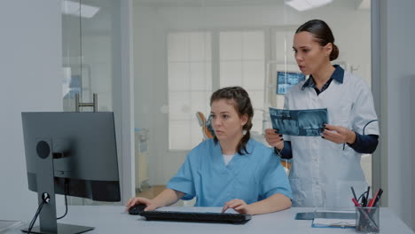 equipo de enfermera y estomatólogo examinando rayos x y computadora