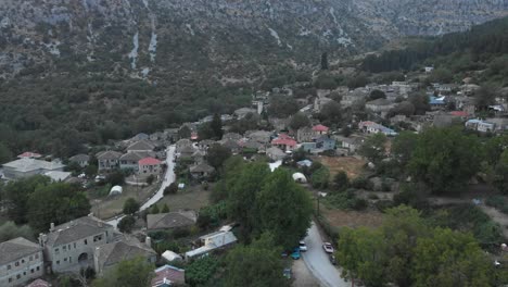 Drone-video-flying-over-Tsepelovo-old-stone-Village-at-Zagori-region-ioannina-Greece-panning-down-looking-at-the-plaza-square