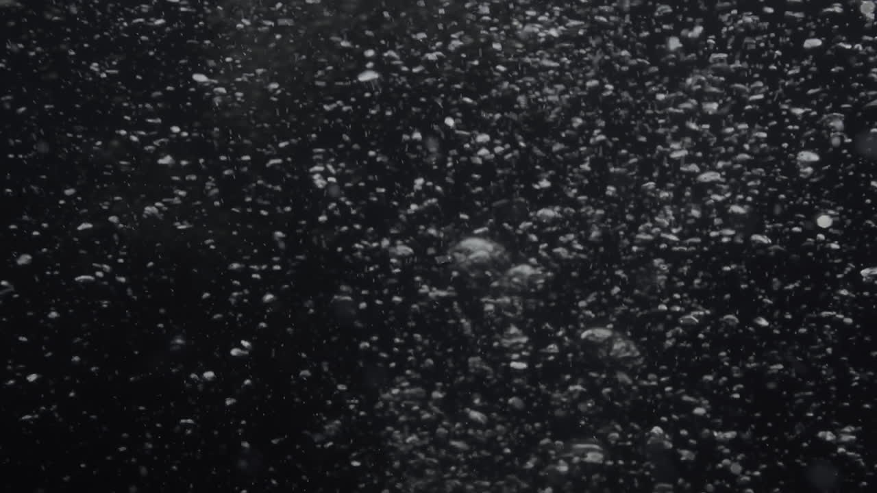Underwater bubbles mayhem on Black Backgrounds. Illuminated bubbles motion. Ocean floor bubbles. Real underwater footage. Deep under sea level. Marine background VFX element.