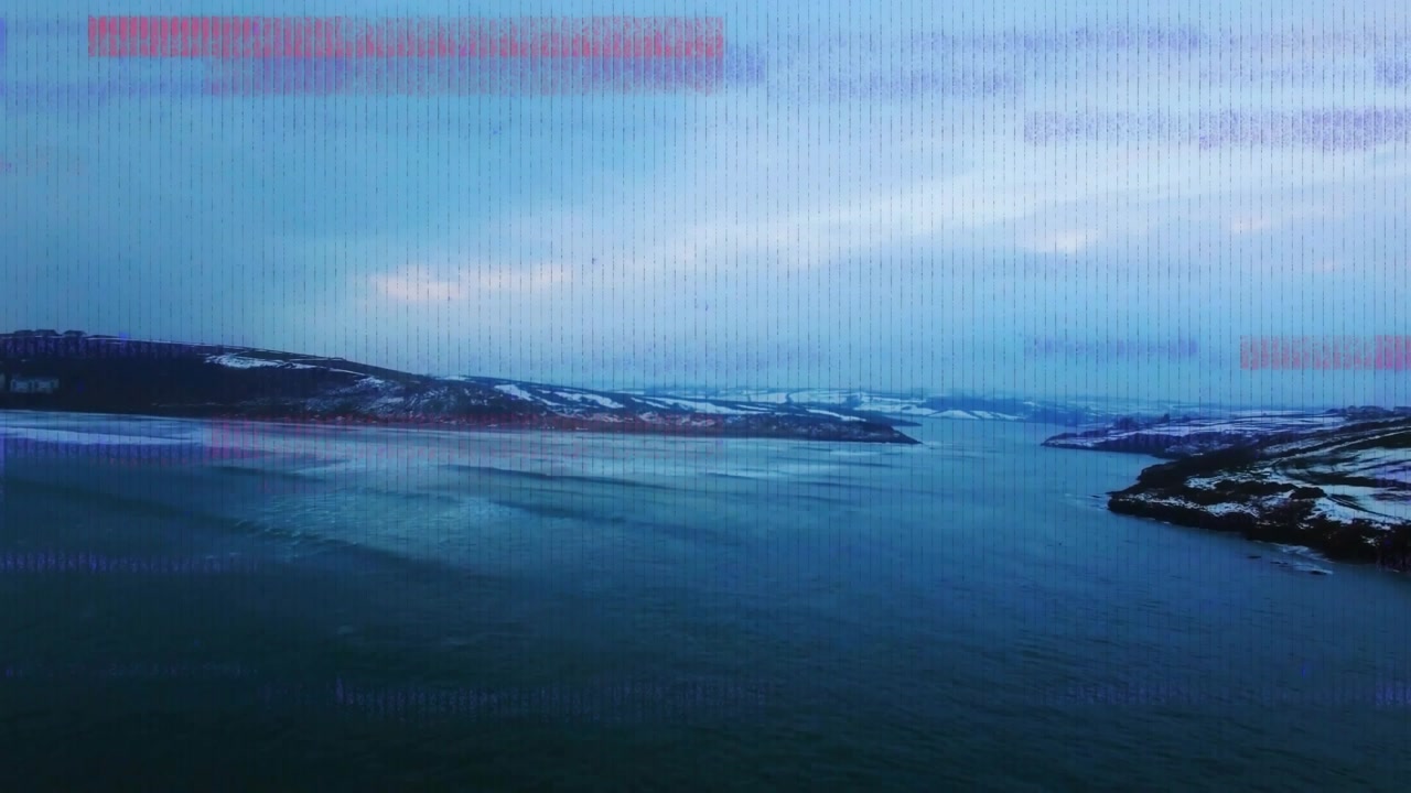 Coastal inlet water showing shifting ripples while colored pixel bands appearing from signal glitch