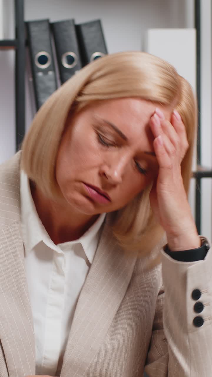Caucasian mature businesswoman reading letters bad news feels upset sitting at home office desk