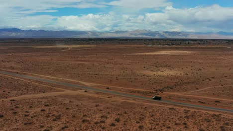 Un-Camión-Solitario-Conduce-Por-El-Medio-Del-Desierto-De-Mojave---Movimiento-Aéreo-Dinámico-Y-Vista-Panorámica