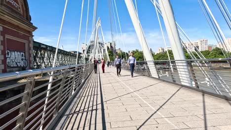 pedestrians crossing a bridge in london