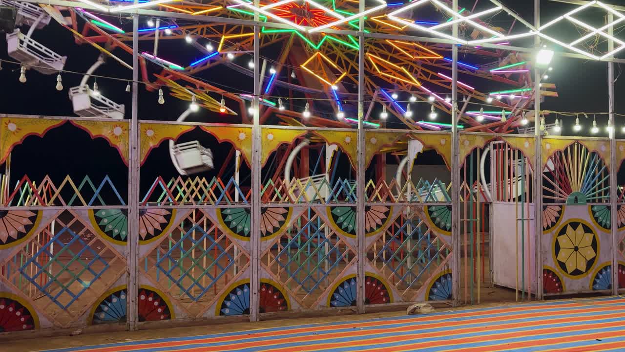 Roda gigante vibrante brilhando com luzes coloridas à noite em uma feira local tradicional