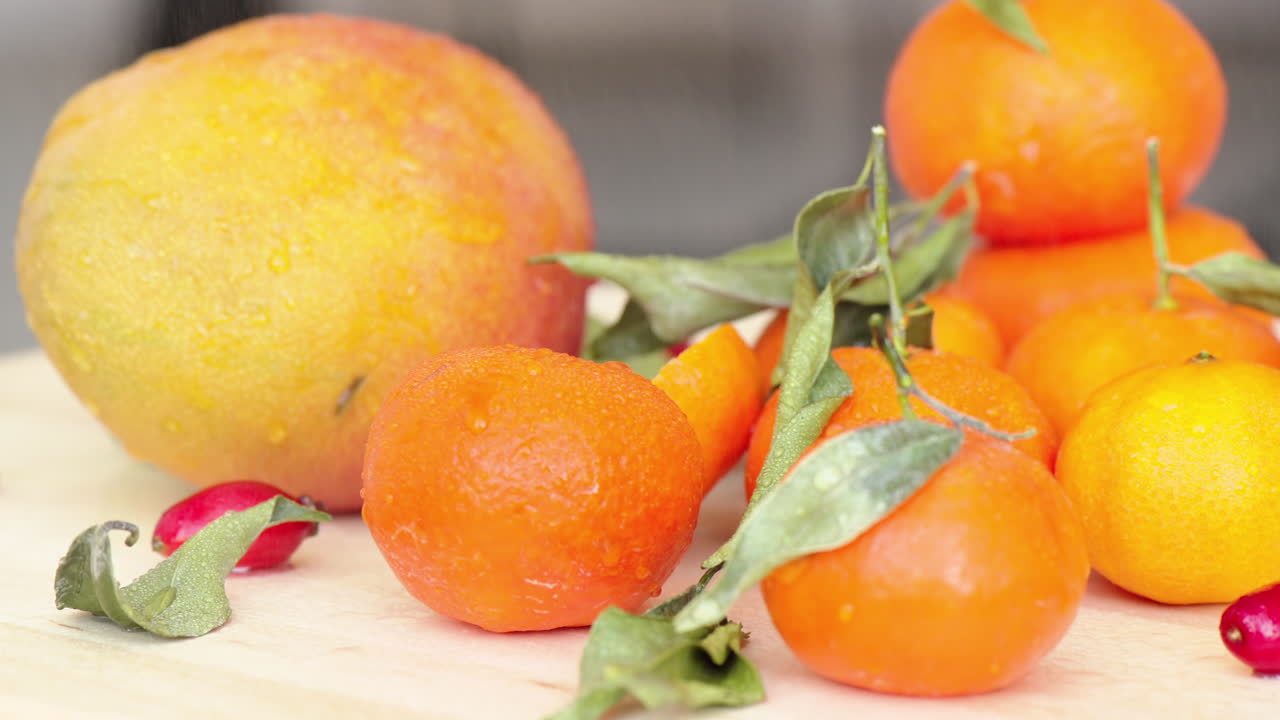 Composition with oranges, mango, rosehip and green leaves, close up