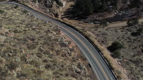 Mountain-Ridge-Highway-Creek-With-Cars-Pan-Down-Aerial-Shot-4K