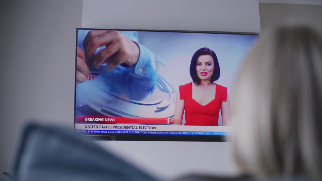 viendo las noticias de las elecciones presidenciales en la televisión.