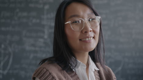 smiling asian woman teacher in classroom