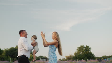 happy young family playing with little daughter in lavender field