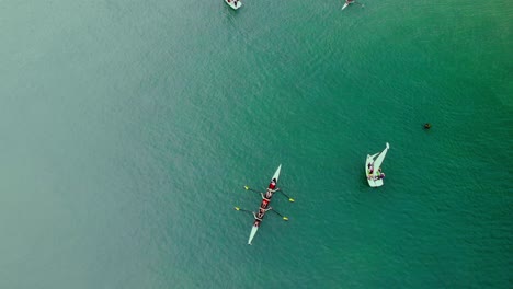 birds eye view of rowing and sailing boats on the turquoise ocean