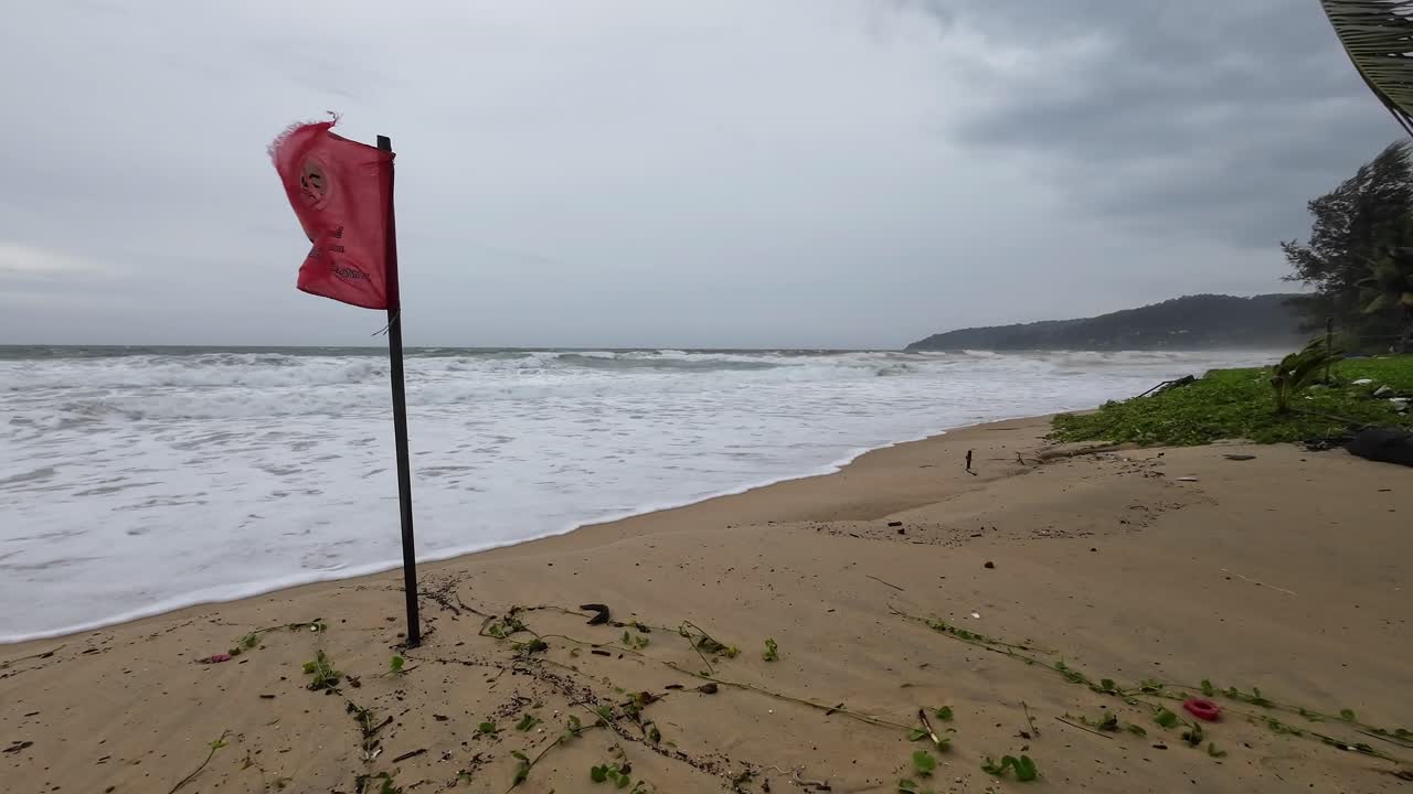 Stormy Beach with Red Warning Flag