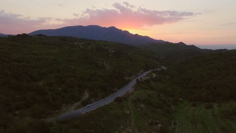 aerial: a car driving during sunset in the mountains of the greek island samos