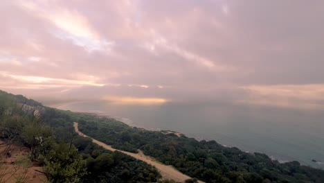 Lapso-De-Tiempo-De-Nubes-En-Movimiento-Sobre-La-Superficie-Del-Agua-Del-Mar,-Luz-Solar-De-ángulo-Bajo-En-El-Horizonte,-Atmósfera-Tranquila-Y-Serena-De-Apariencia-Natural-A-Lo-Largo-De-La-Costa-Del-Océano