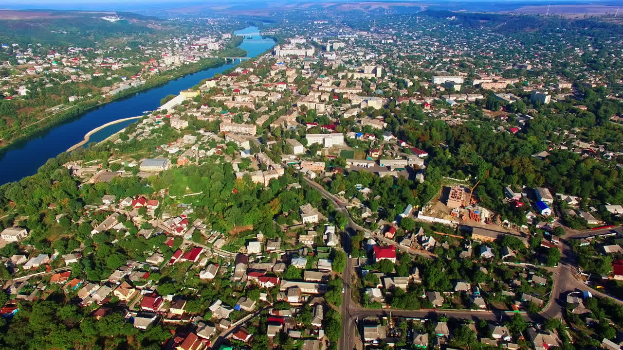 Vast panorama of the colorful city on beautiful sunny day. Urban landscape split by the narrow river with bridges. Top view.