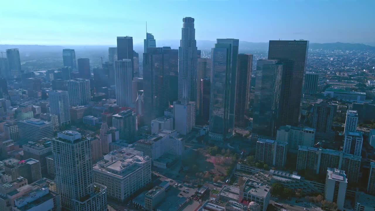 el horizonte del centro de los ángeles - vuelo de drones entre los rascacielos de la ciudad - tarde soleada