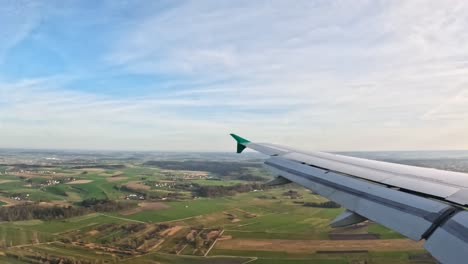 flying over scenic farmland, aerial view of plane wing with beautiful landscapes below