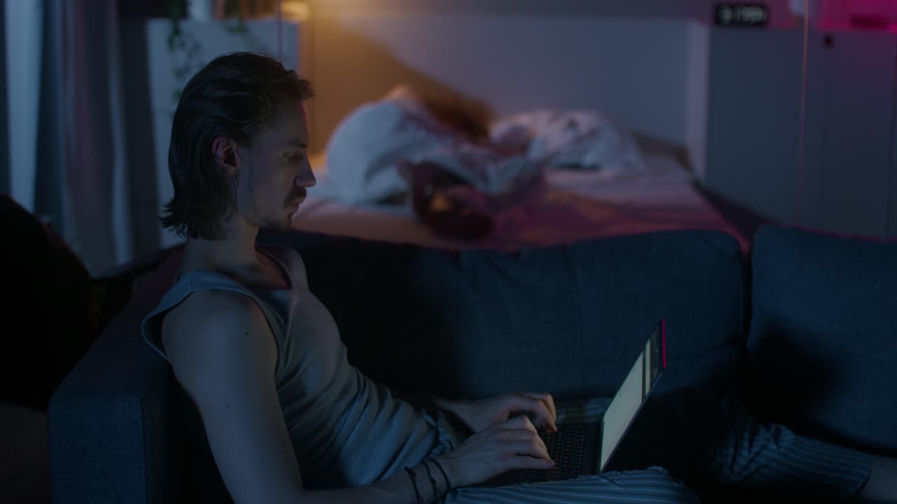 человек работает на ноутбуке поздно ночью.