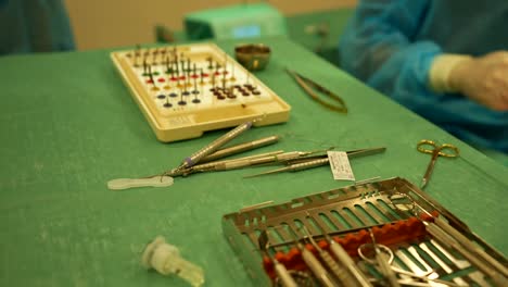close-up of dental surgical instruments on a green drape