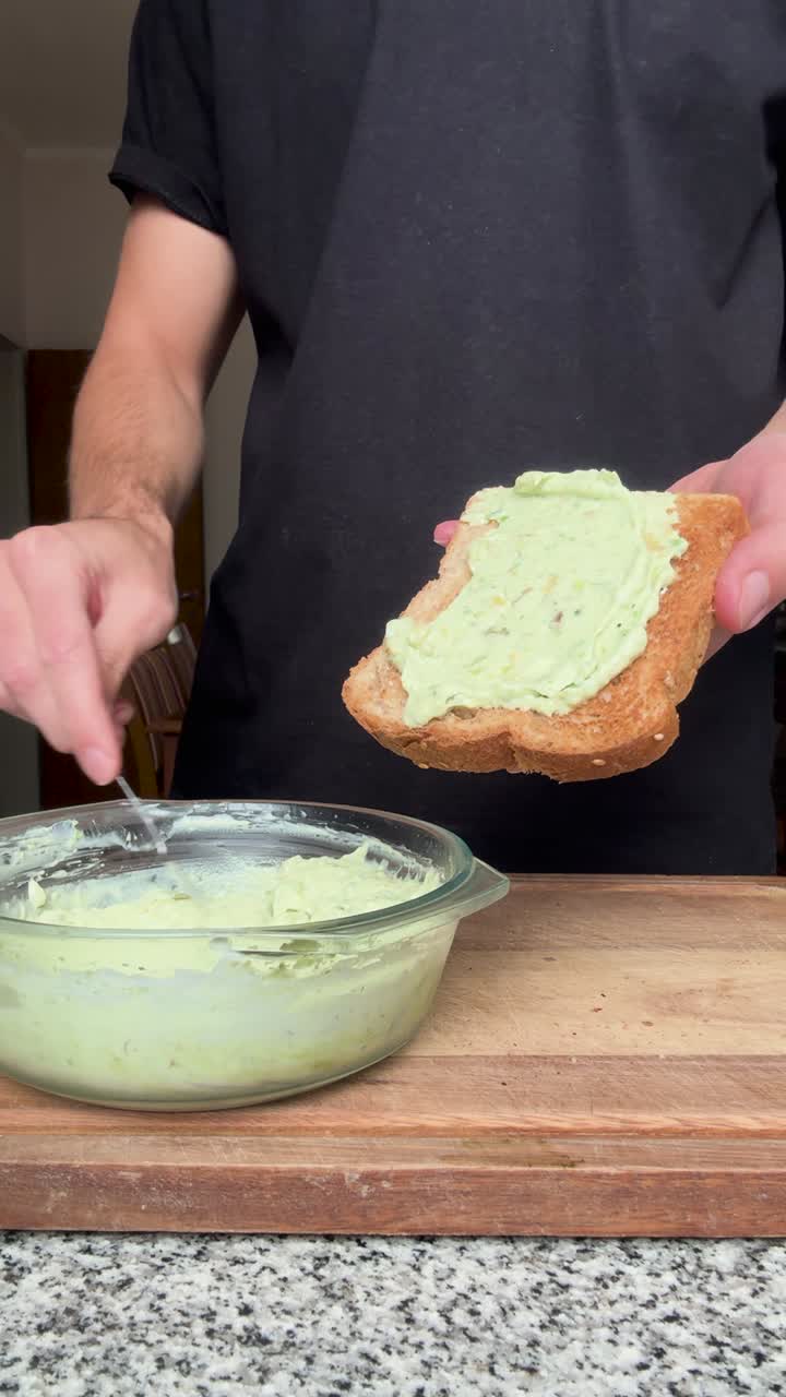 Uomo che prepara toast all'avocado fatto in casa per colazione