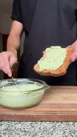 man making homemade avocado toast for breakfast