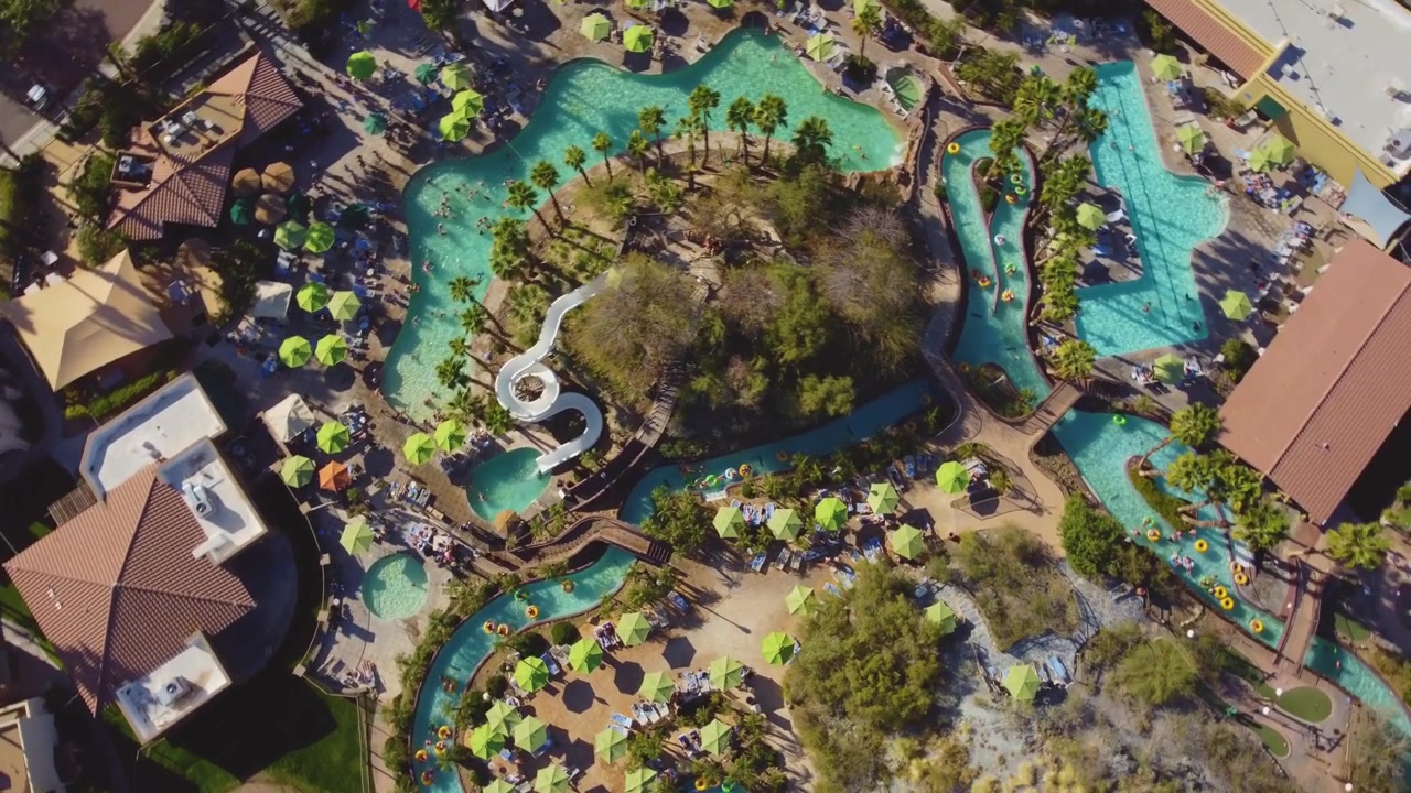A top rotating drone captured a water park with people enjoying the various rides.