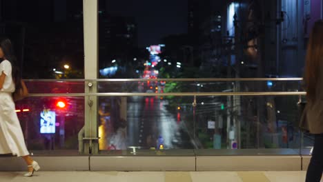 People Walking on Night City Bridge
