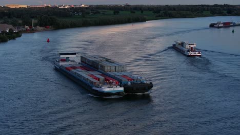 Drohnenansicht-Von-Frachtschiffen-Mit-Bunten-Containern,-Die-Auf-Dem-Fluss-Fahren-Und-Fracht-Transportieren