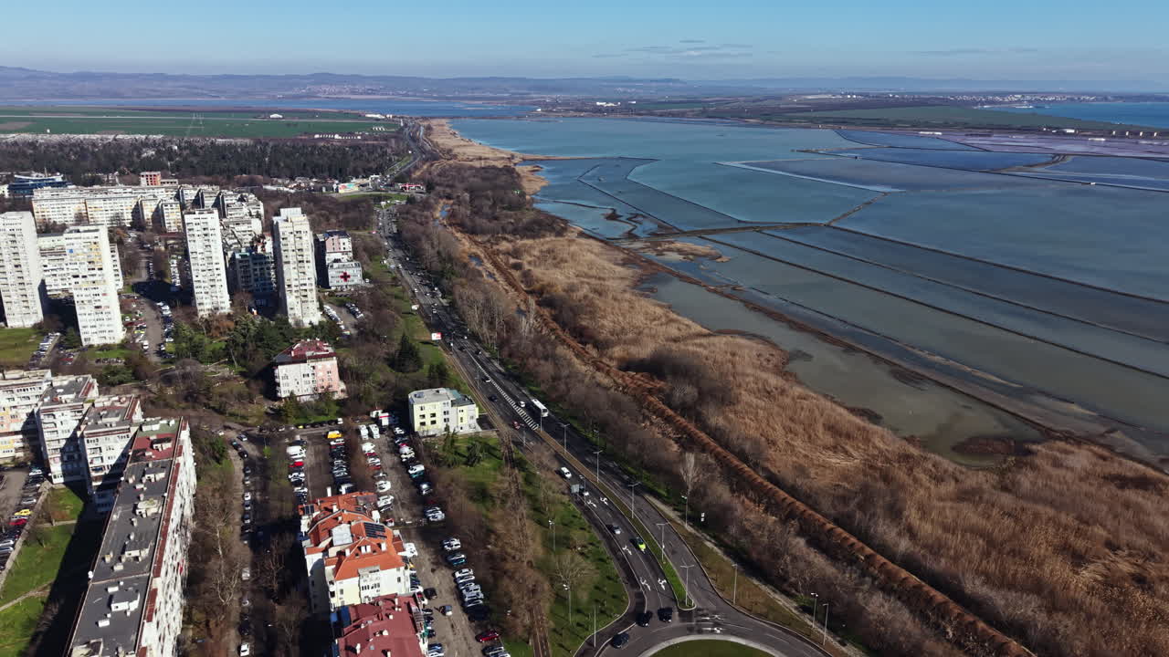 Vista di un'area urbana vicino all'acqua con edifici, strade e campi in una giornata limpida al mattino