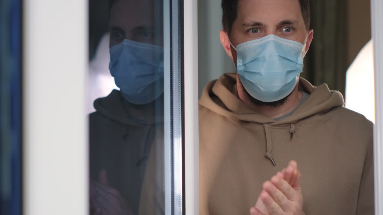 hombre con una máscara facial junto a una ventana