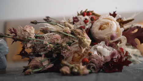 Dried-floral-arrangement-on-textured-backdrop