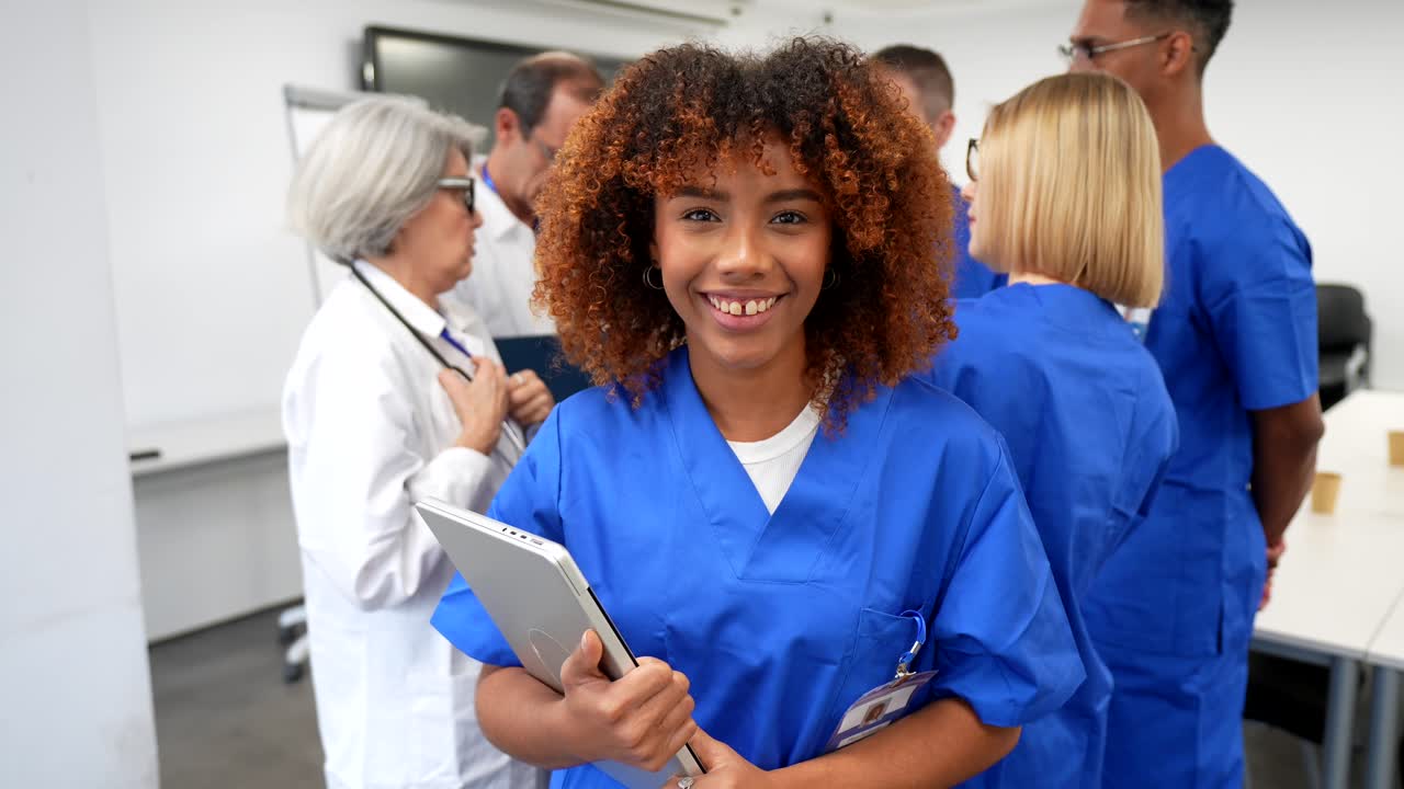 Selvsikker ung kvindelig læge smilende med bærbar computer på hospitalet.