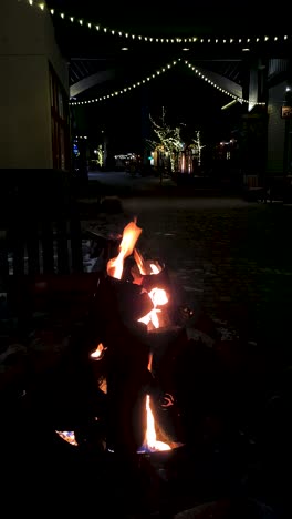 vertical video, outdoor gas fire pit in cold winter christmas night, lake tahoe ski resort, california usa